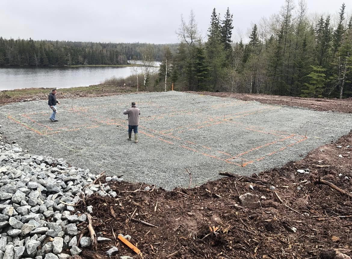 Gravel building pad staked out beside the water